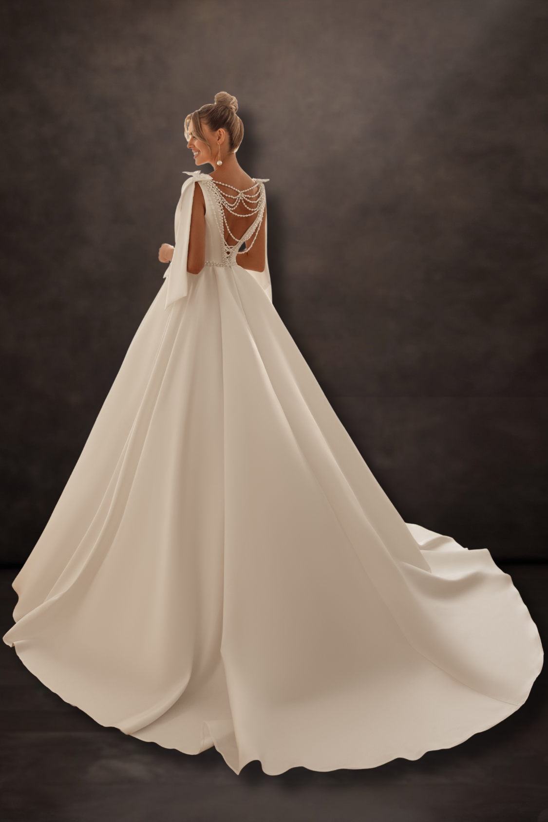 Off White wedding dress with intricate back design on a dark background